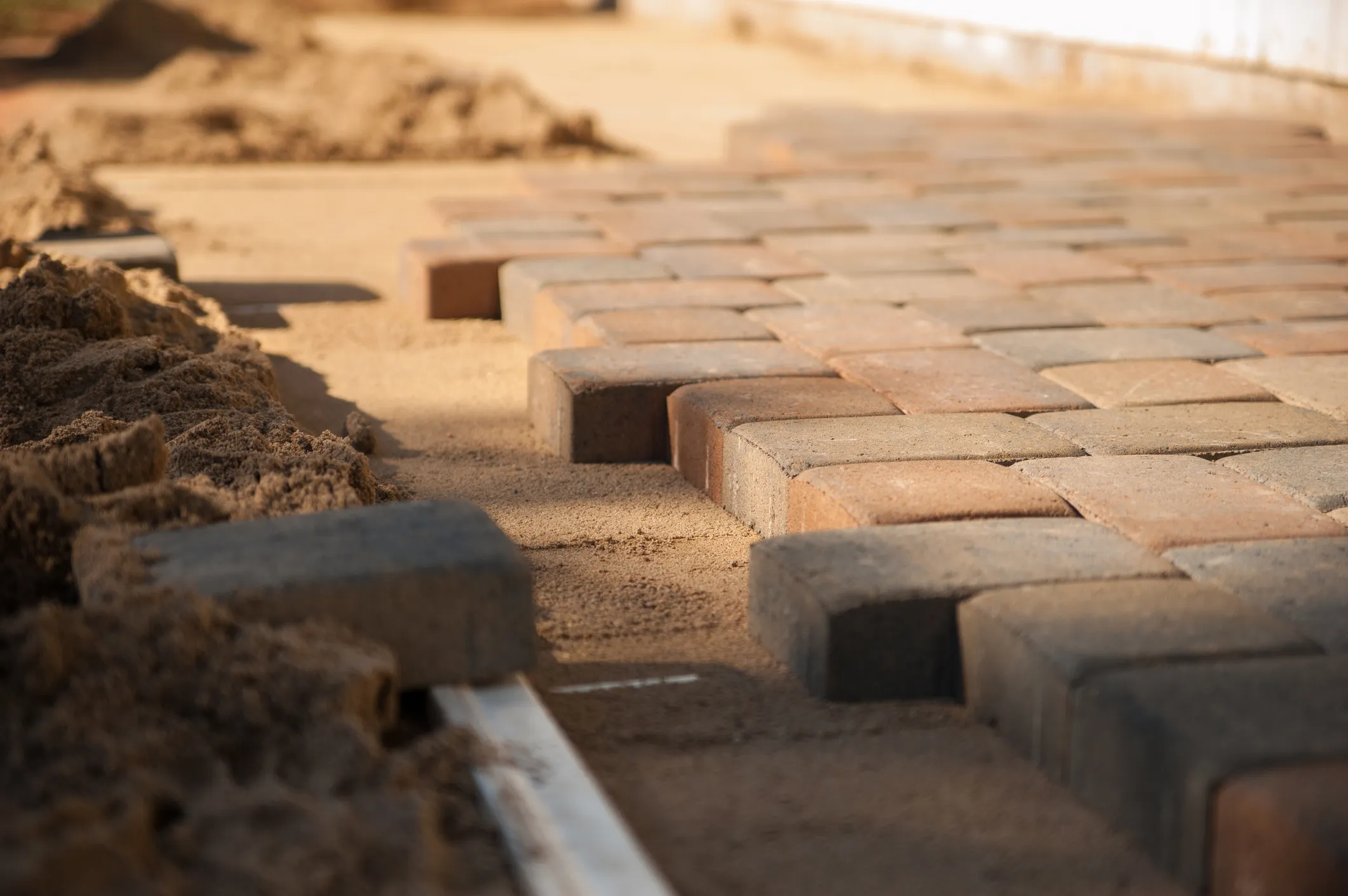 Brick patio under construction with compacted base and edging forms. Featured in the Installation Guides section.