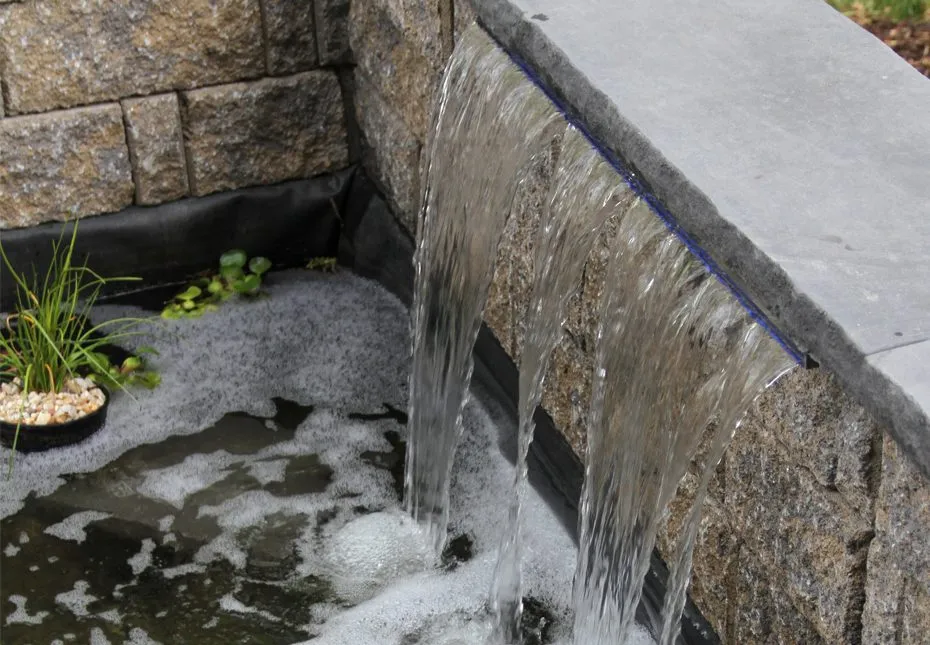 A stone outdoor water feature at a residence, featured in project photos.
