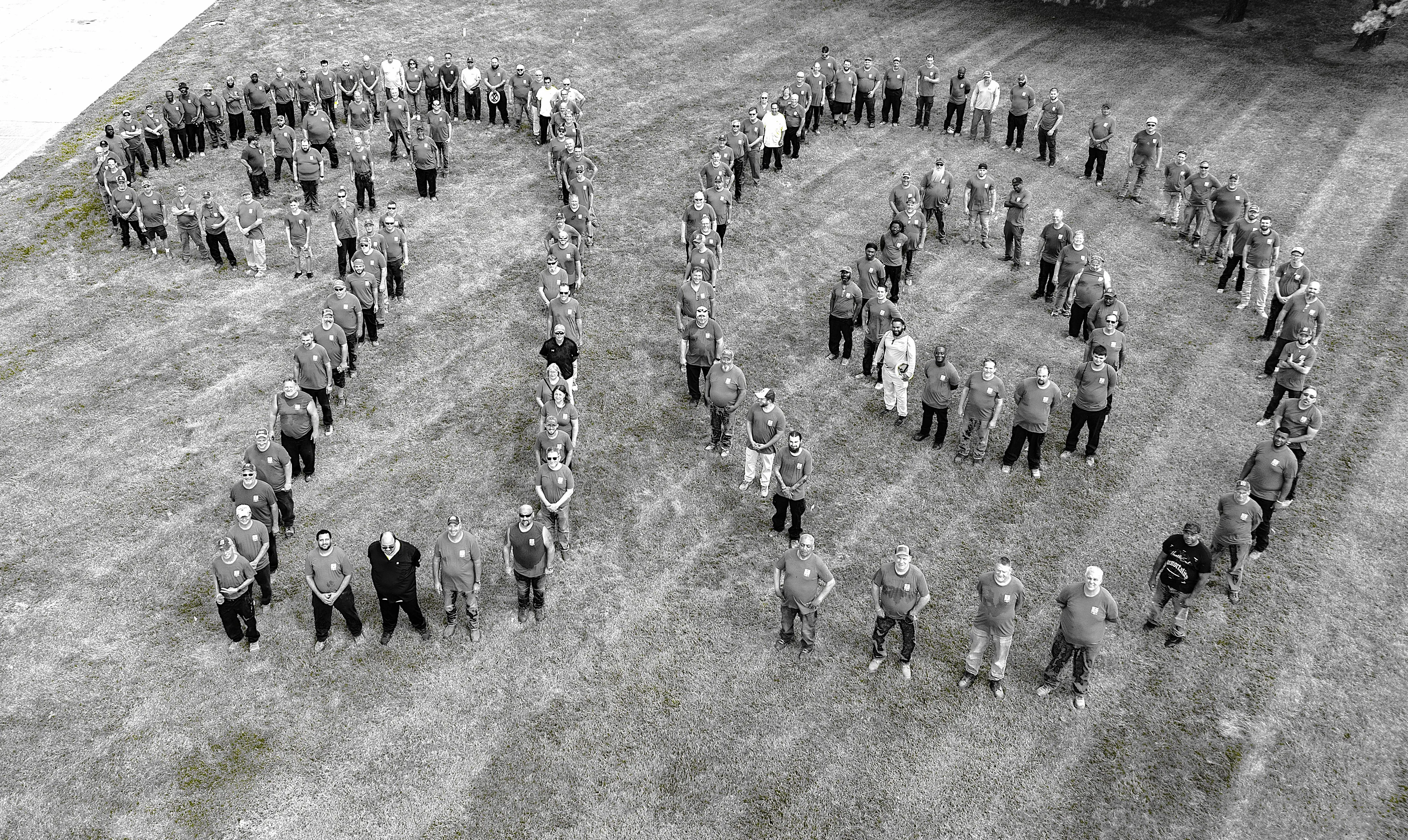 Team members celebrating 90th anniversary event, featured in the News section at Newline Hardscapes.